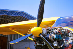A bright yellow plane on a service on a sunny day.